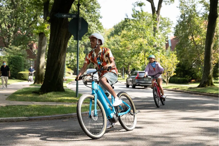 a group of people riding e-bikes on a street