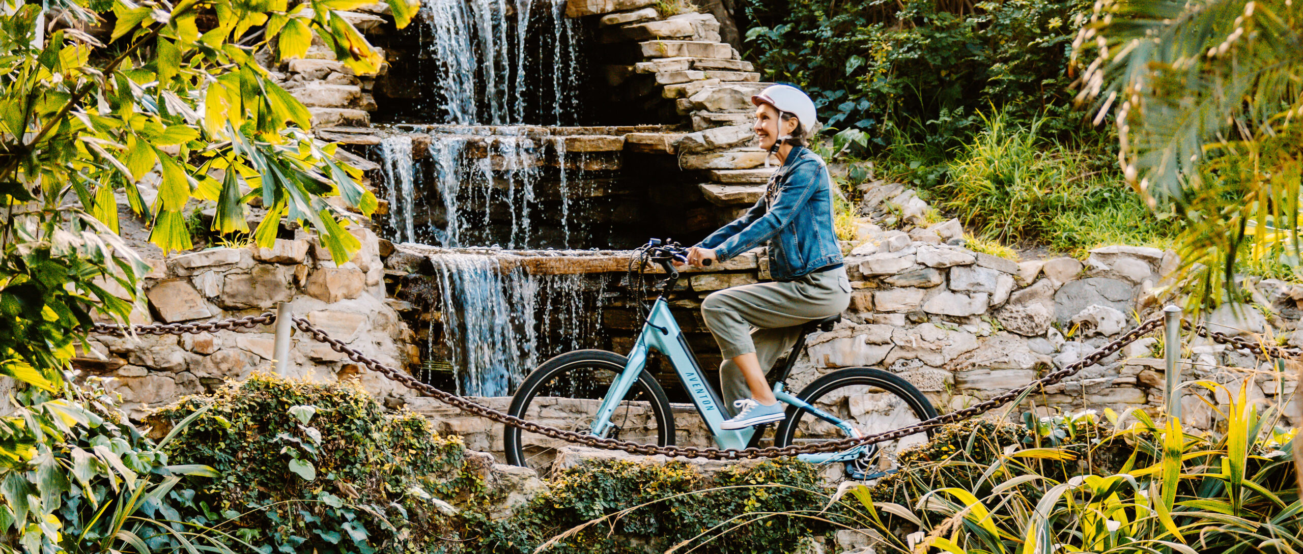 a woman riding a e-bike near a waterfall