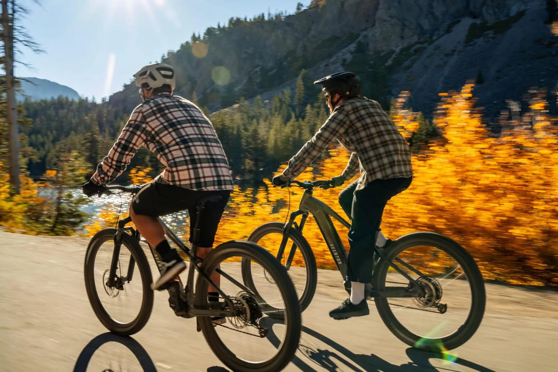 two men riding e-bikes on a road