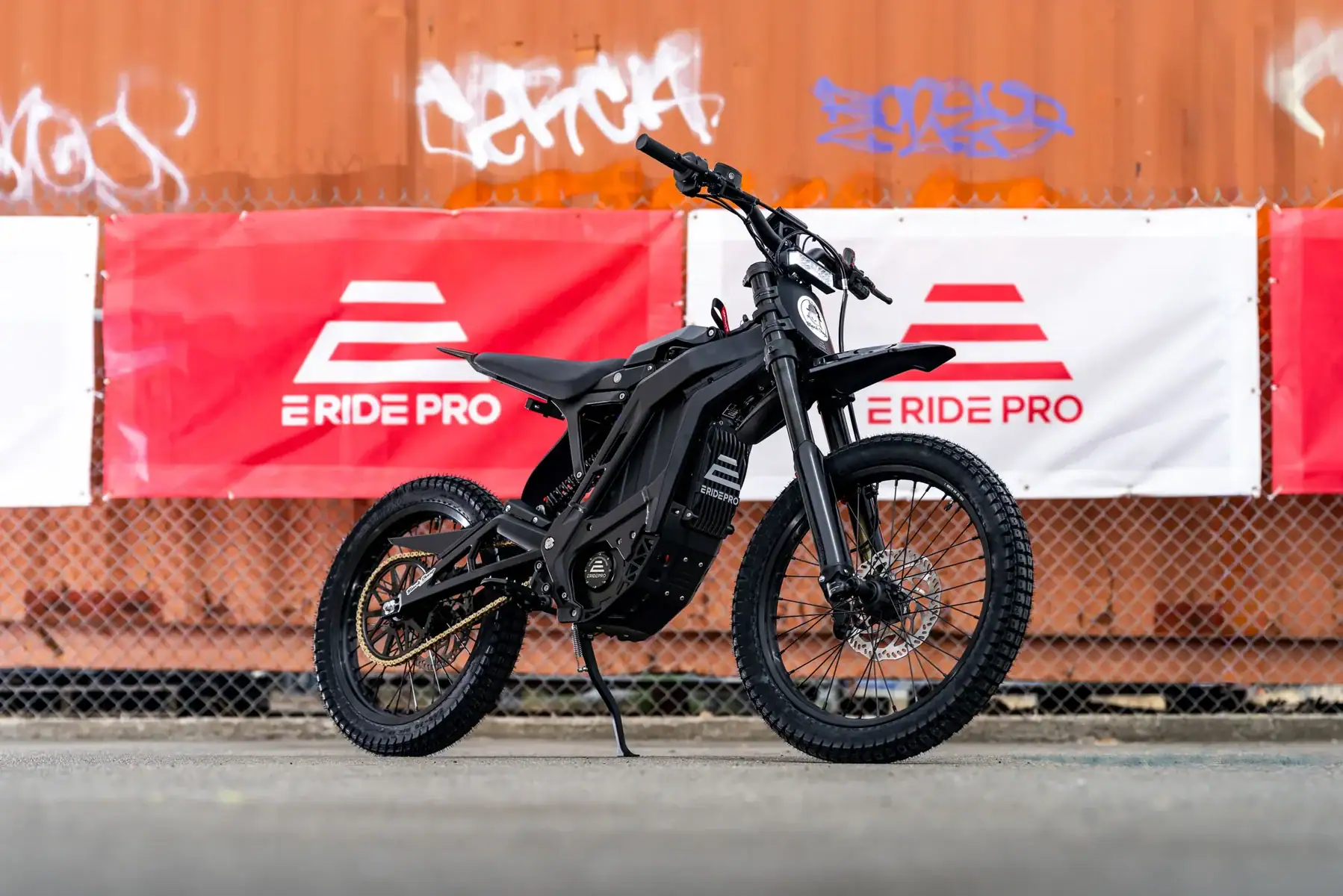E Ride Pro 3.0 electric dirt bike parked in front of E Ride Pro banners