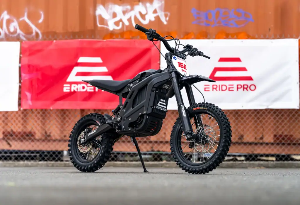 E Ride Pro electric dirt bike parked in front of E Ride Pro banners outdoors