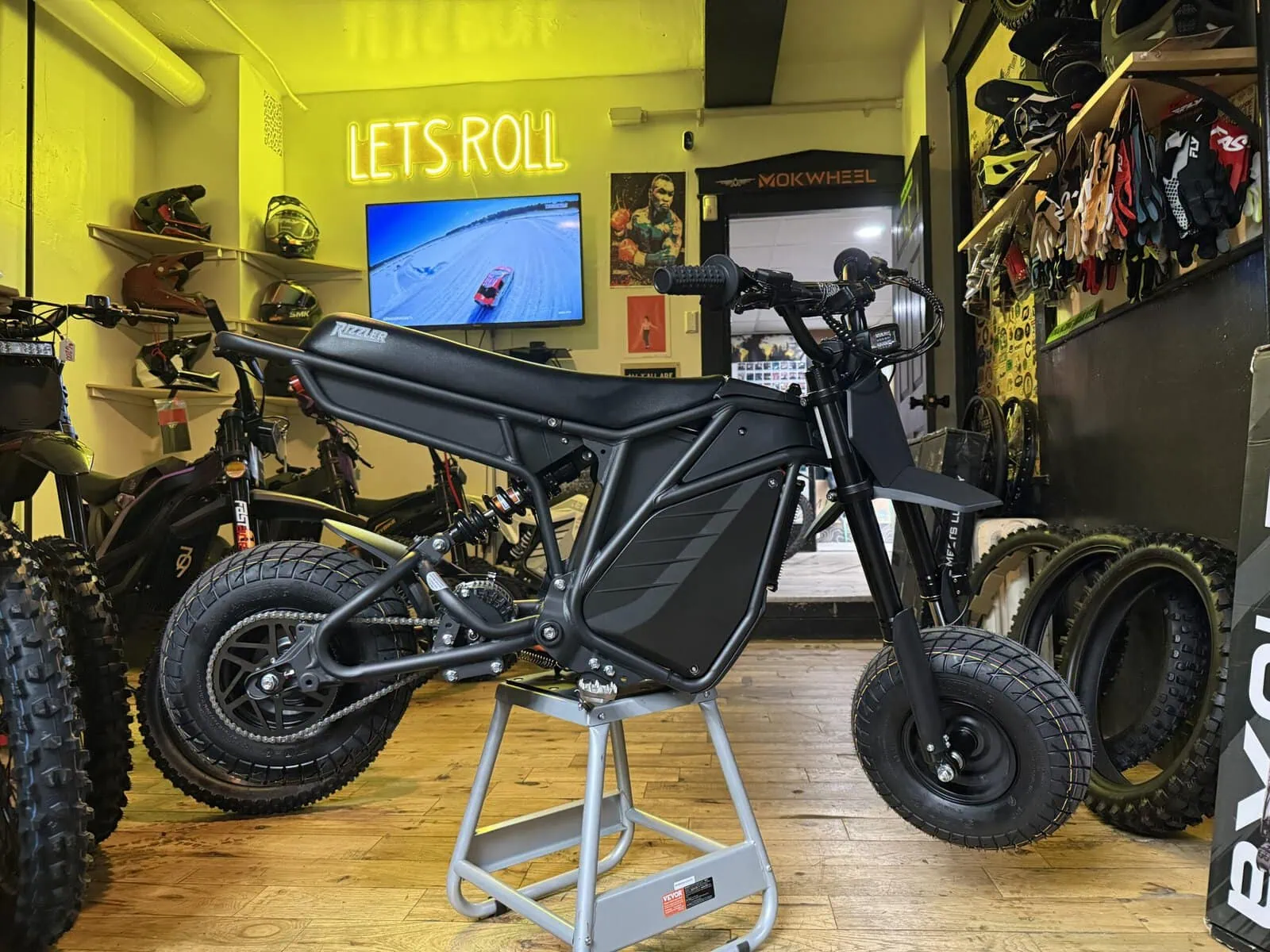 Let's Roll Lancaster e-bike shop interior showing multiple electric dirt bikes and helmets