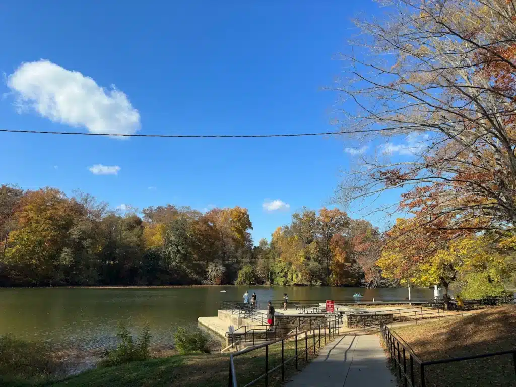 Fishing pier extending into Lake Roland with fall foliage along the far shore