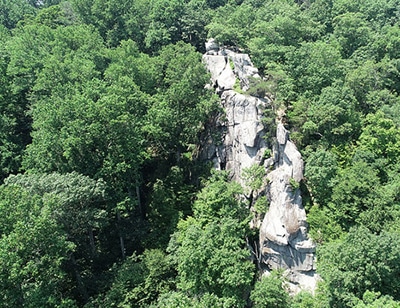 The King and Queen Seat rock outcrop rising above dense green forest at Rocks State Park
